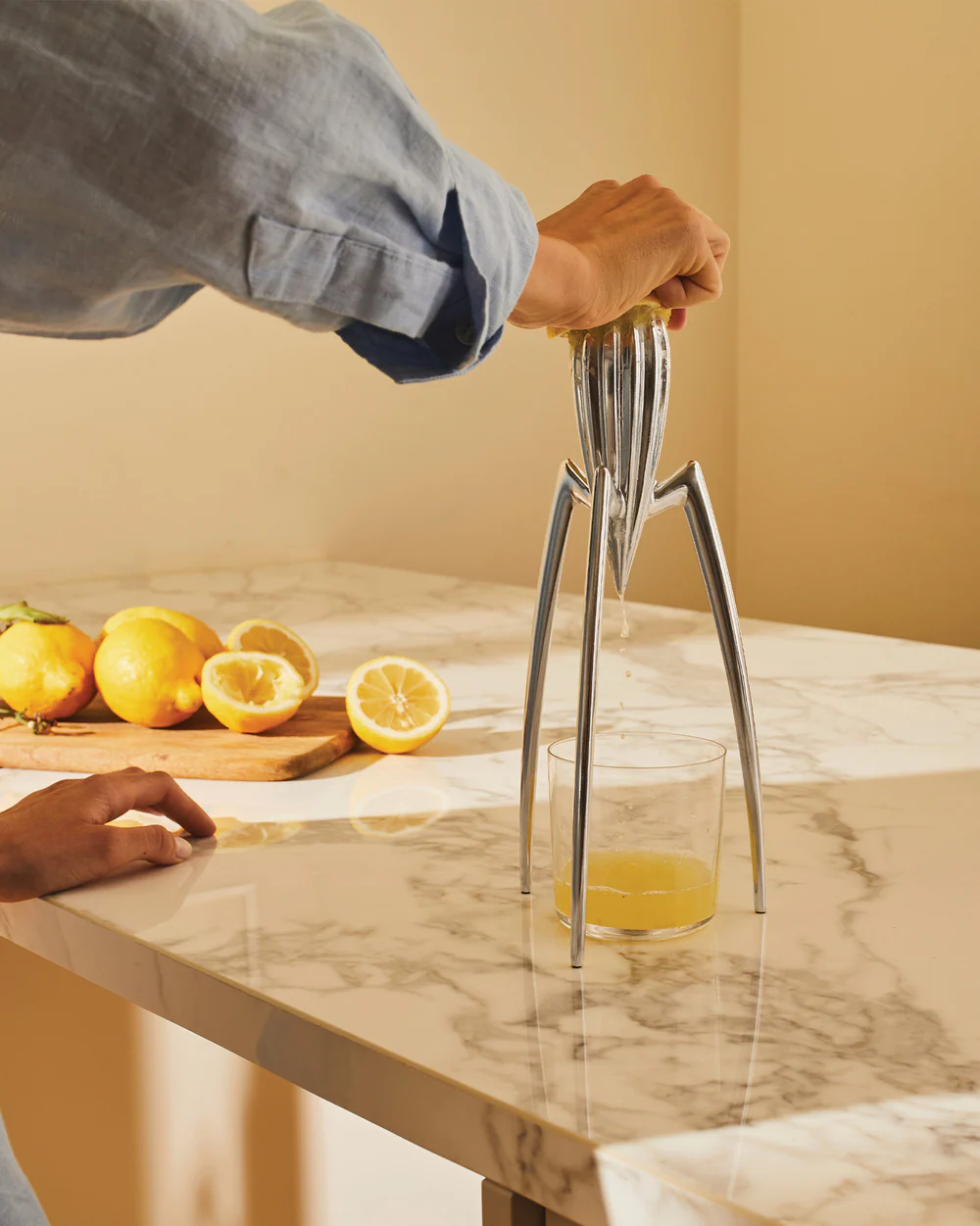 Dettaglio delle gambe in alluminio del Juicy Salif, lucidato a specchio che riflette la cucina circostante